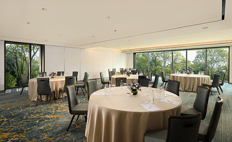 Luxurious indoor venue for meeting and private event with verdant greenery and banquet set up